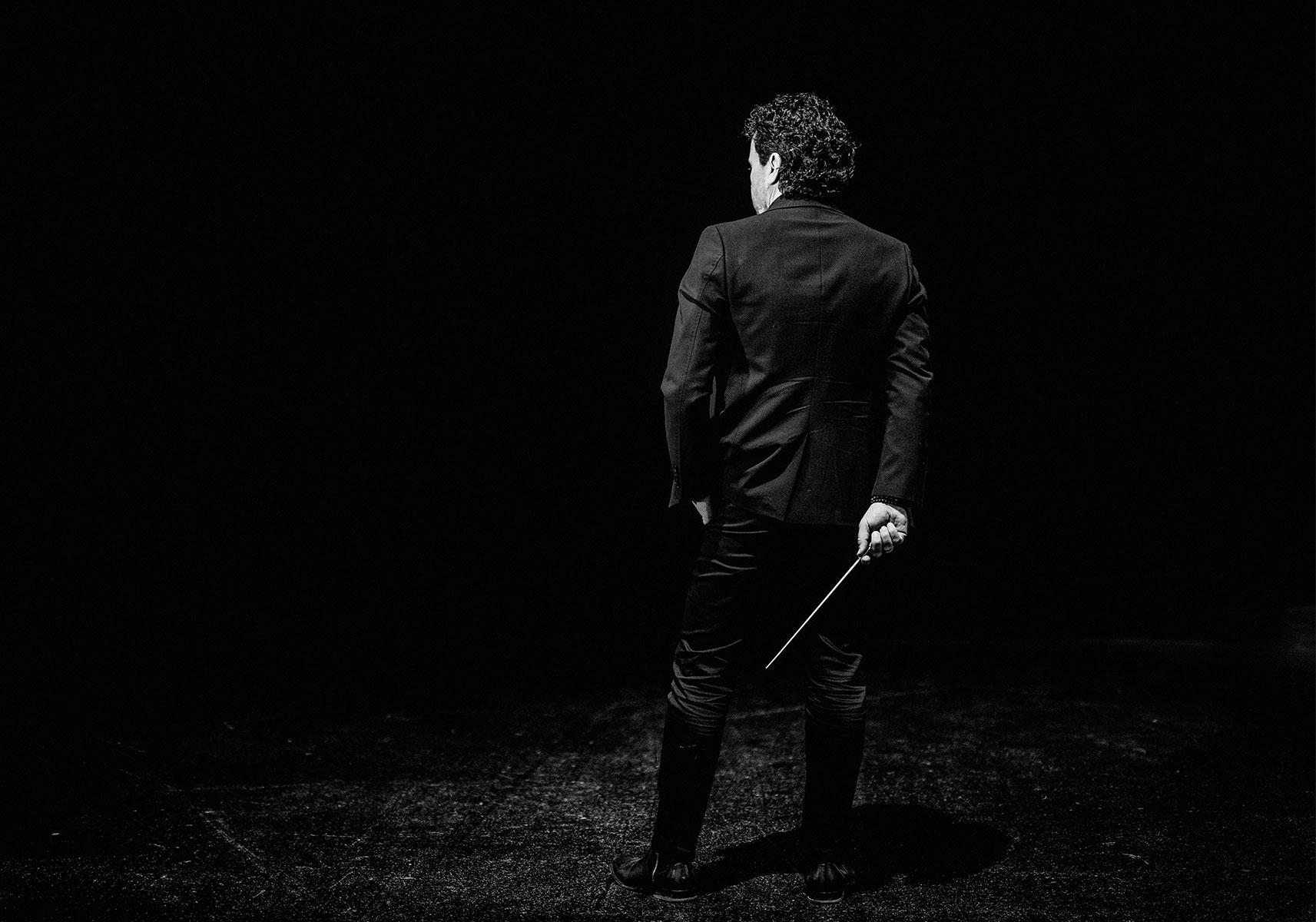 Paul Lorenz alone on a darkened stage